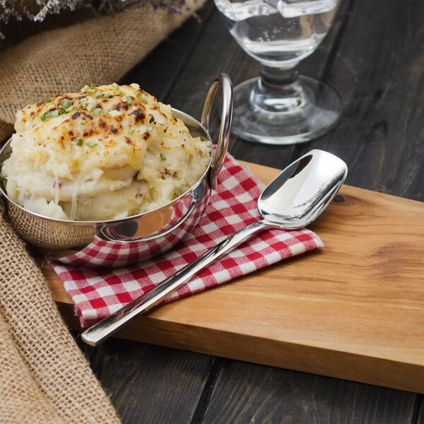 A bowl of mashed potatoes with a Walco stainless steel spoon.