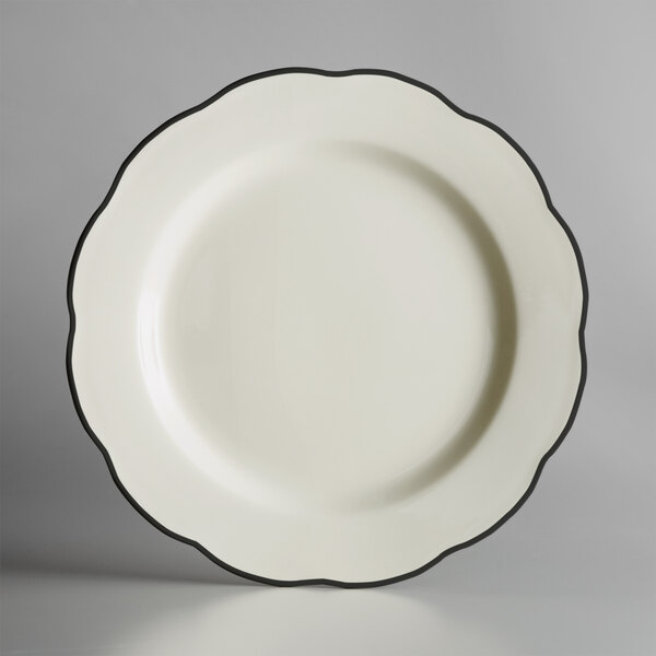 A CAC ivory china plate with a scalloped edge and black trim.