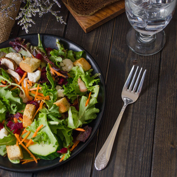 A salad on a plate with a Walco stainless steel salad fork.