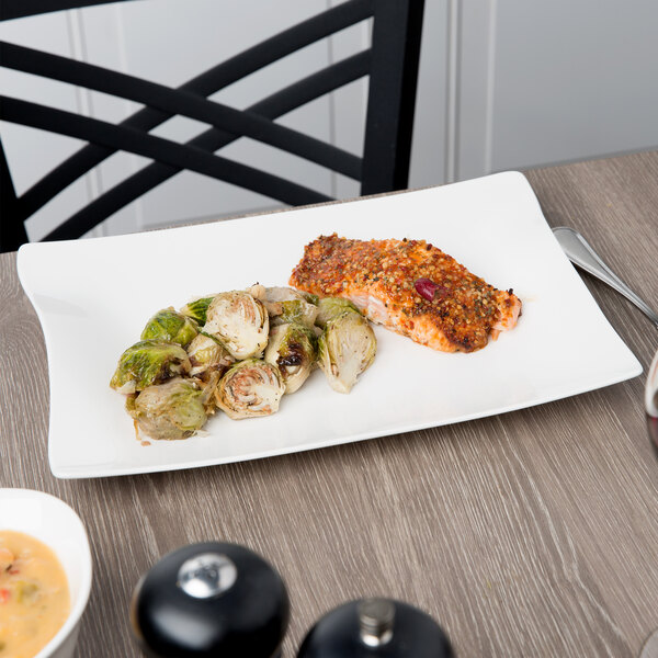A Villeroy & Boch white porcelain rectangular plate with food on a table.