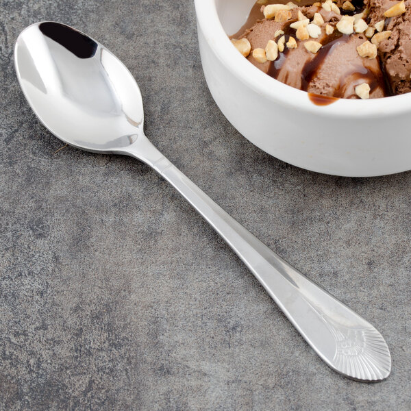 A close up of a Walco Meteor stainless steel dessert spoon with chocolate ice cream, nuts, and chocolate topping.
