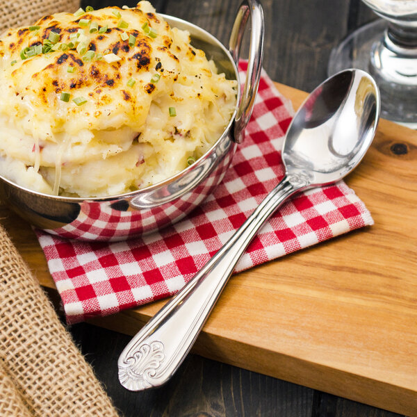 A bowl of mashed potatoes with a Walco Danish Pride teaspoon on a table.