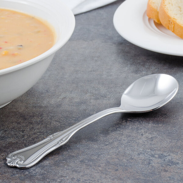A Walco Barony bouillon spoon in a bowl of soup on a table.