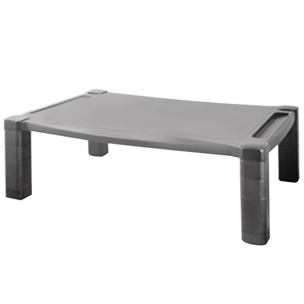 A Kantek black plastic monitor stand on a grey table.