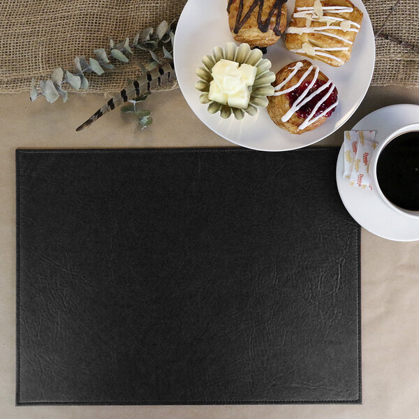 A black H. Risch, Inc. rectangle placemat with a plate of pastries and a cup of coffee on it.