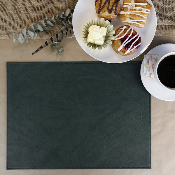 A Harley green faux leather rectangle placemat on a table with a white plate of muffins and a cup of coffee.