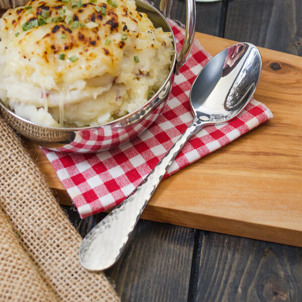A bowl of mashed potatoes with a Walco stainless steel teaspoon.