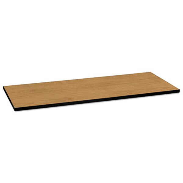 A rectangular wood table top with a black edge on a brown table base.
