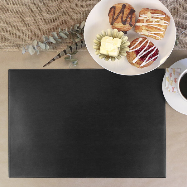 A black customizable vinyl rectangle placemat with coffee and donuts on a table.