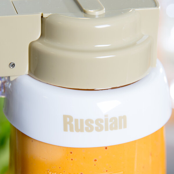 A close up of a white plastic Tablecraft "Russian" salad dressing dispenser collar with beige lettering.