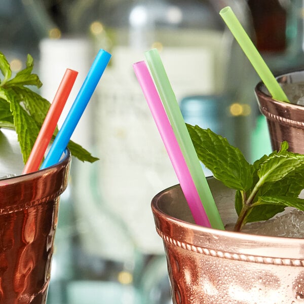 A group of copper cups with Choice neon beverage stirrers.
