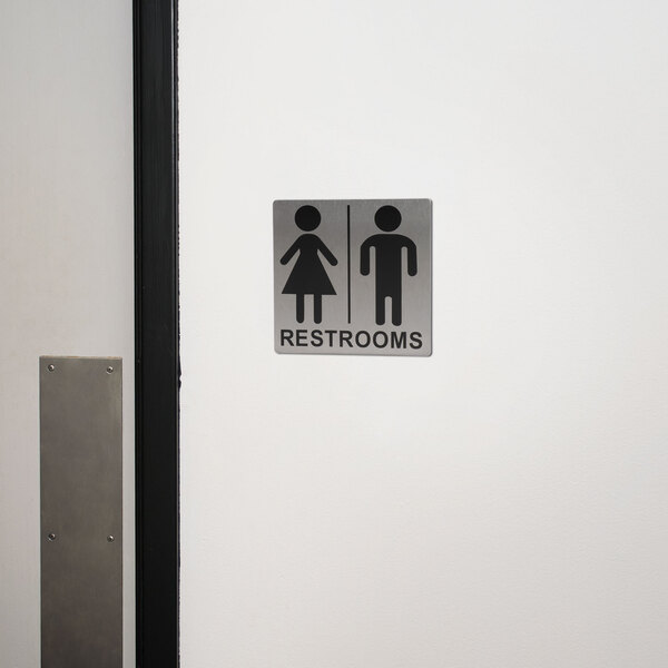 A Tablecraft stainless steel restroom sign with a man and woman symbol.
