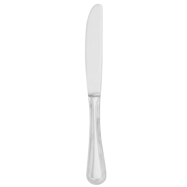 A Walco stainless steel dinner knife with a solid white handle and clear blade.