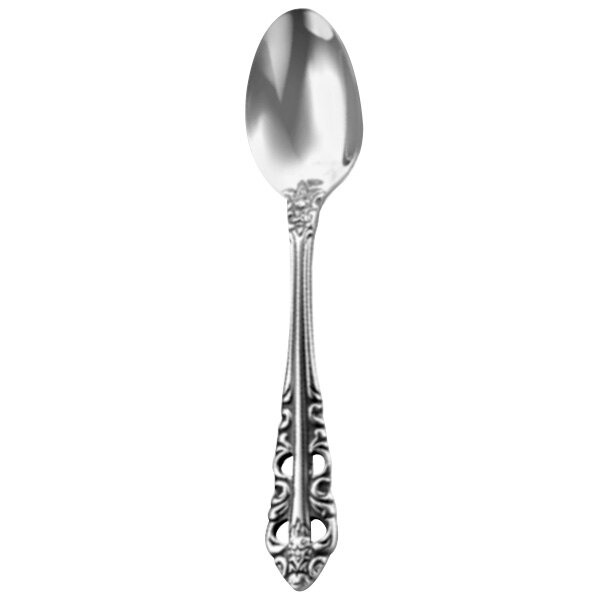 A close-up of a Walco stainless steel demitasse spoon with an ornate design.