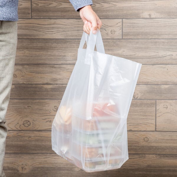 A person holding a Polyethylene Soft Loop Handle Bag with food in it.