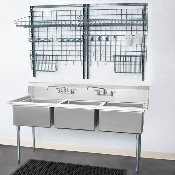A Metro SmartWall G3 dish washing station above a sink with a faucet and shelf.