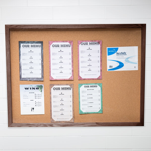 An Aarco walnut enclosed bulletin board displaying menus.
