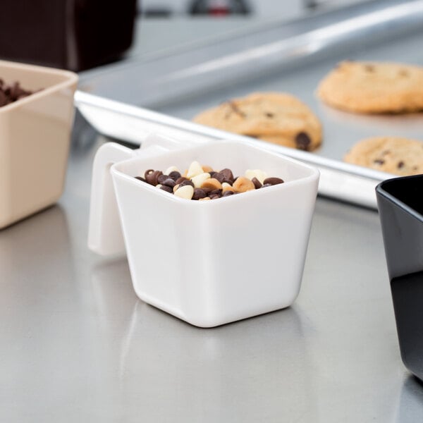A white Carlisle portion scoop with chocolate chips in a white cup.