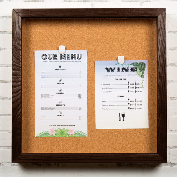 An Aarco enclosed cork board with a framed menu and wine glass inside.