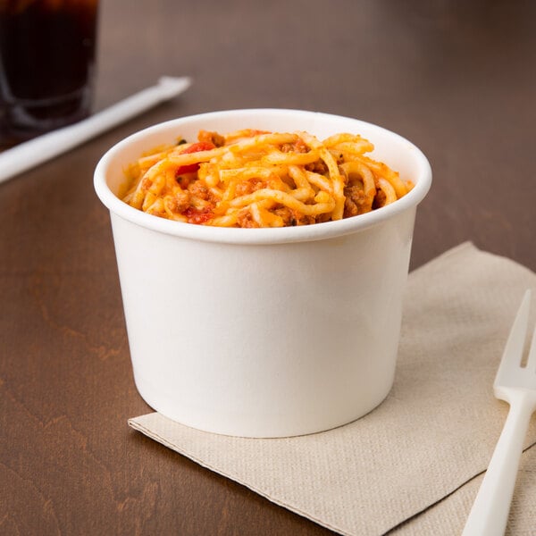 A white Choice paper cup filled with spaghetti on a napkin with a fork.