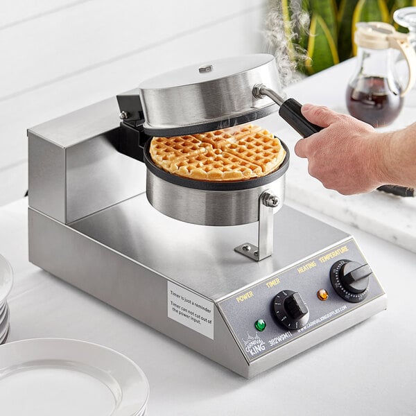 A person using a Carnival King single waffle maker to bake a waffle.