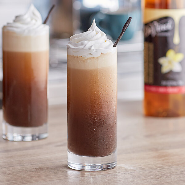 Two glasses of vanilla-flavored drinks with whipped cream on top.