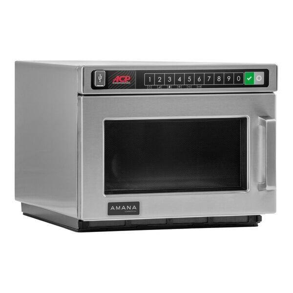 An Amana stainless steel commercial microwave on a counter.