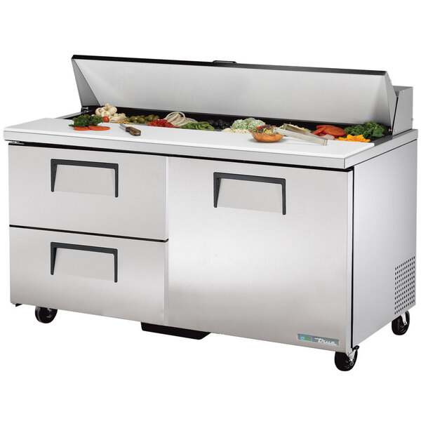 A stainless steel True refrigerated sandwich prep table with a large drawer and food on top.