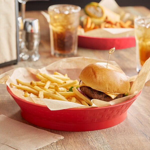 A cheeseburger and fries served in a red Choice fast food basket with base.