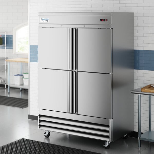 A stainless steel commercial reach-in freezer with four solid half doors on casters.