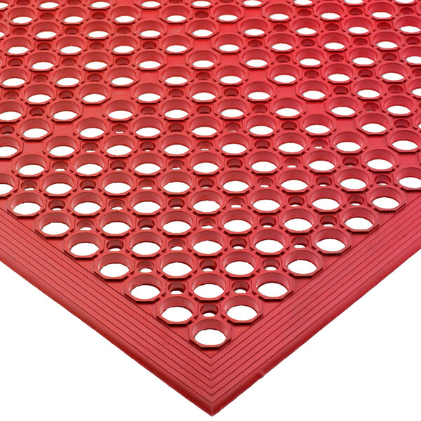 A red San Jamar rubber floor mat with holes in it.