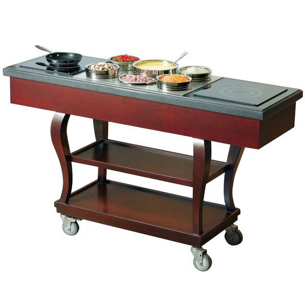 A Bon Chef wood mobile induction range cart on a table with food.