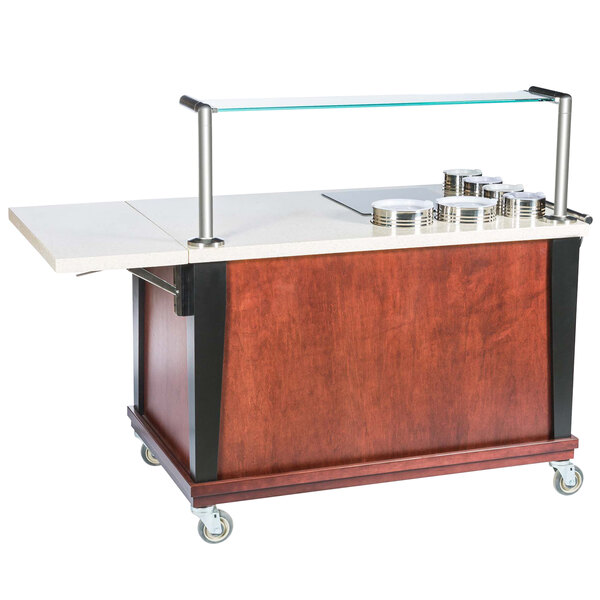 A Bon Chef wood and glass mobile induction action cart with stainless steel shelves and silver plates on top.