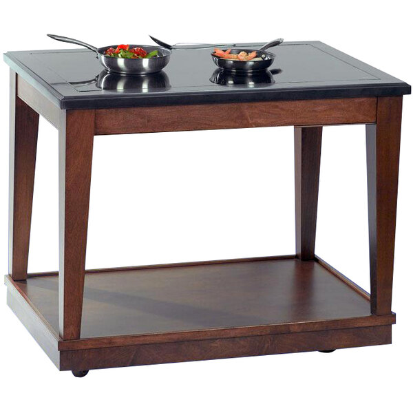 A Bon Chef mahogany station table with two induction warmers and pans on it.