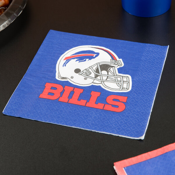 A blue and white Creative Converting Buffalo Bills luncheon napkin with a football helmet on it on a table.