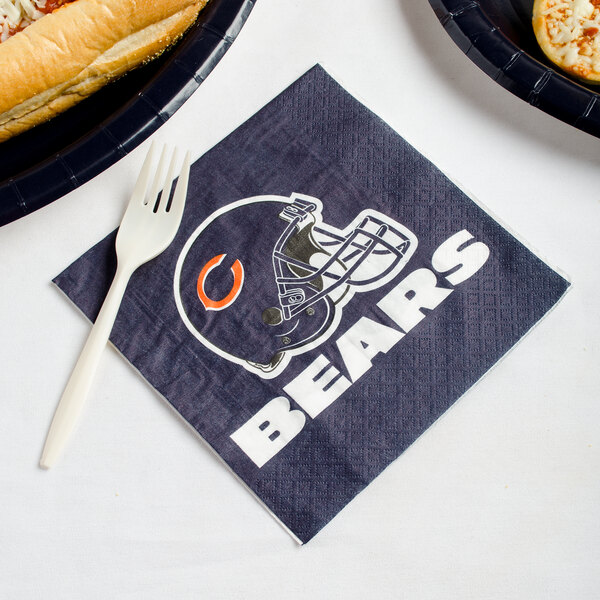 A Chicago Bears luncheon napkin with a sandwich and a fork on a table.