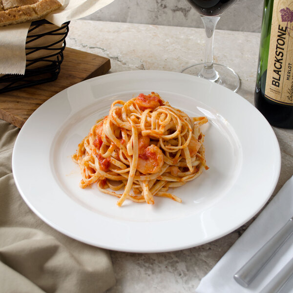 A plate of spaghetti with shrimp and wine on a white Villeroy & Boch porcelain plate.