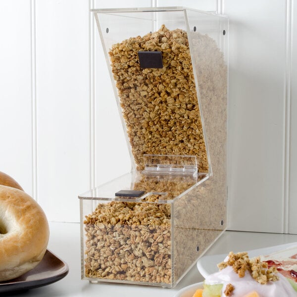 A clear stackable container with cereal in it on a hotel buffet table.