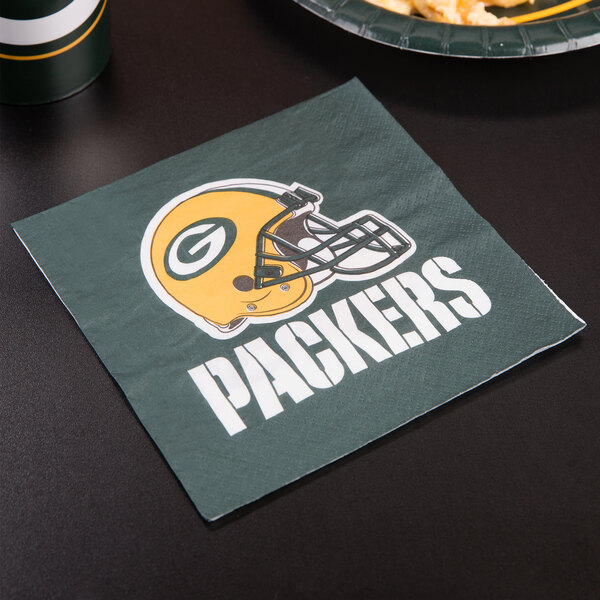 A Creative Converting Green Bay Packers luncheon napkin with a helmet on it on a table.