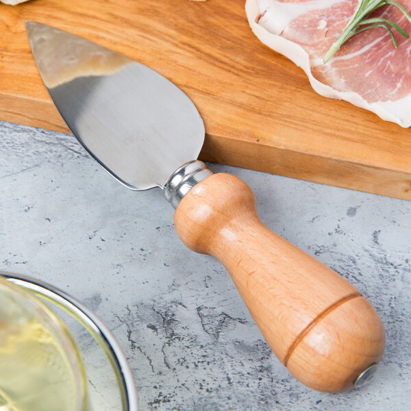 A Franmara stainless steel cheese knife with a beechwood handle on a cutting board.