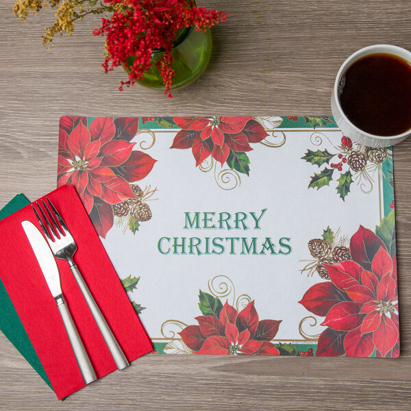 A Hoffmaster Merry Christmas placemat with silverware and a cup of coffee on a table.