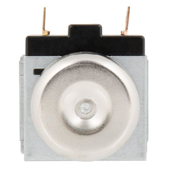 A close up of a small metal silver timer with a round metal object.