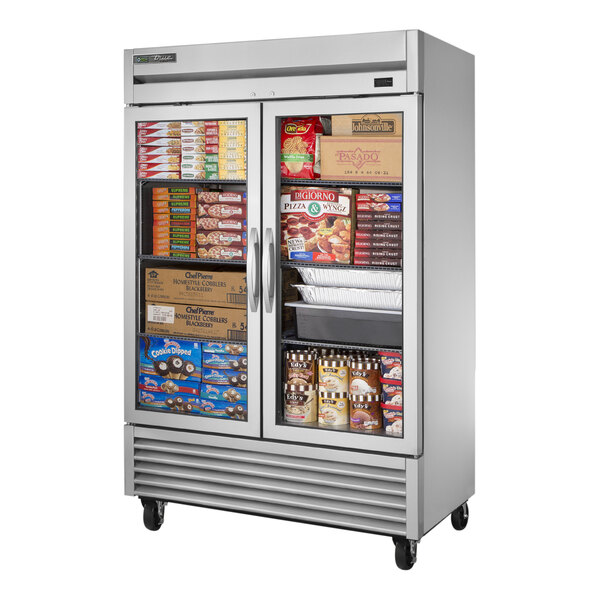 A True 2 section glass door reach-in freezer filled with a variety of food items.