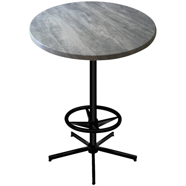 A round Holland Bar Stool outdoor bar height table with a grey stone top and a black metal base.