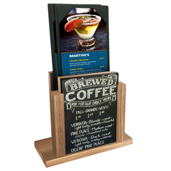 A Menu Solutions weathered walnut wood menu holder with a chalkboard insert on a table with a drink and a menu.