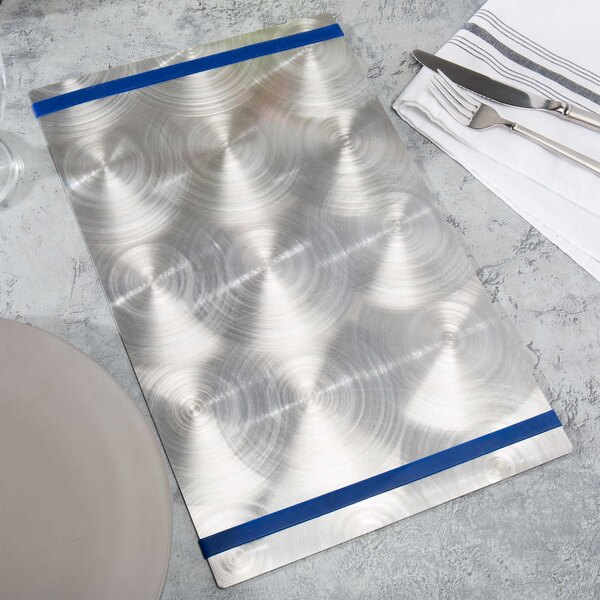 An Alumitique silver menu board with navy bands on a table with silverware and a napkin.
