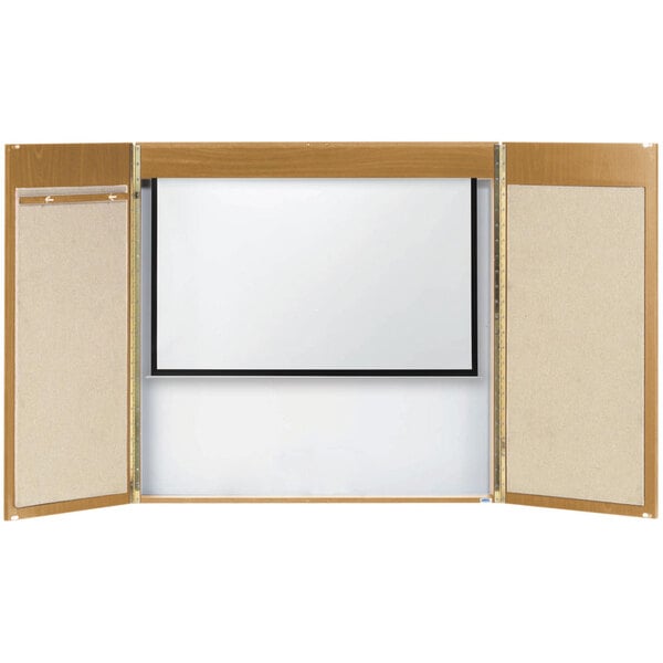 An Aarco oak laminate conference cabinet with a white board and projection screen inside a wooden frame with a brown border.