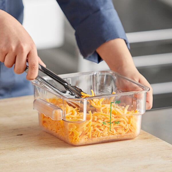 A person cutting up cheese in a Choice square food storage container.