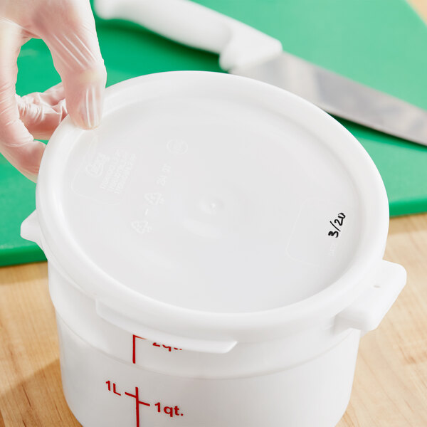 A gloved hand placing a white Choice round polypropylene lid on a white plastic container.