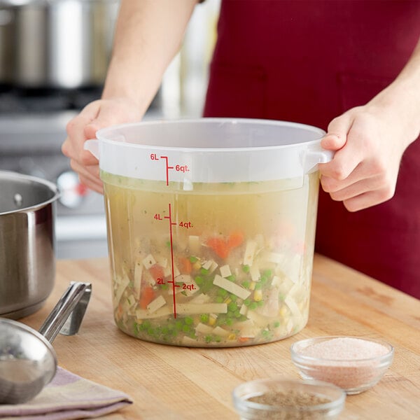 A person holding a large Choice translucent plastic food storage container with food in it.